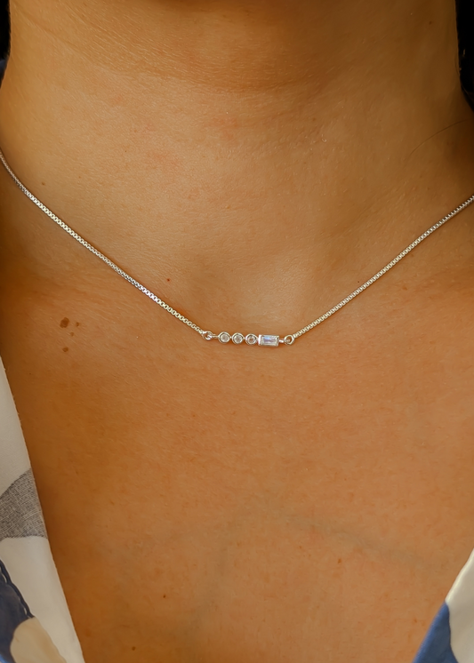 Dainty Sterling Silver letter 'V' Morse Code necklace with delicate moonstone beads, showcasing its subtle minimal look.